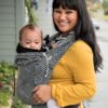 Woman carries baby in Didymos DidyKlick baby carrier in Metro Monochrome