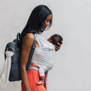 Woman carries baby on her front in the Freerider baby sling, side view