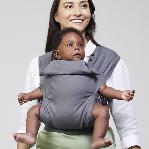 Woman carries baby facing forwards in Izmi Baby Carrier