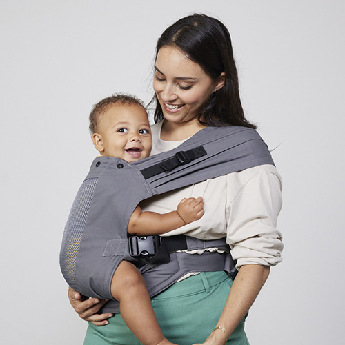 Woman carries toddler on her hip in Izmi Breeze Toddler Carrier