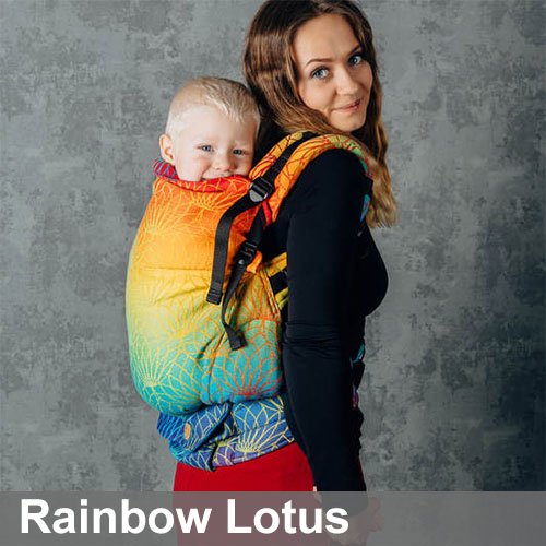 Woman carries toddler on her back in Lenny Lamb Preschool carrier in Rainbow Lotus fabric