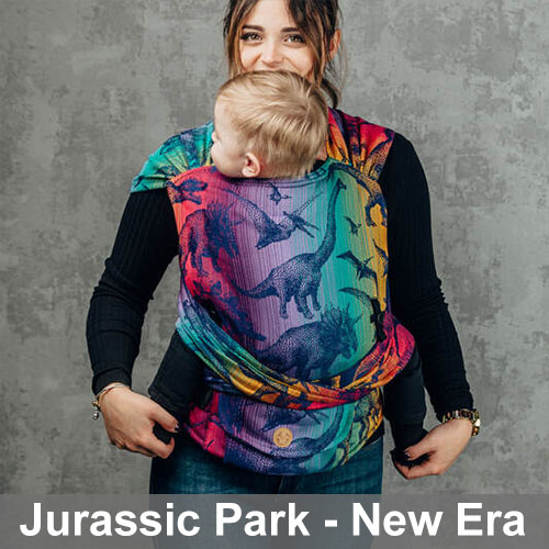 Woman carrying baby on her front in Lenny Lamb Lenny Hybrid Half Buckle Baby Carrier in Jurassic Park New Era, front view