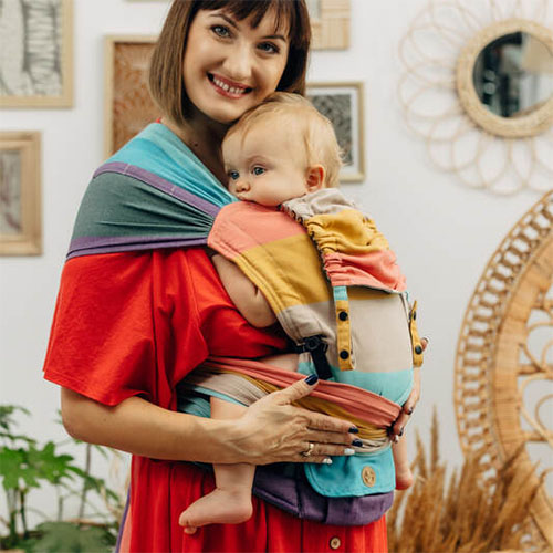 Woman carrying baby on her front in Lenny Lamb Lenny Hybrid Half Buckle Baby Carrier in Pastels