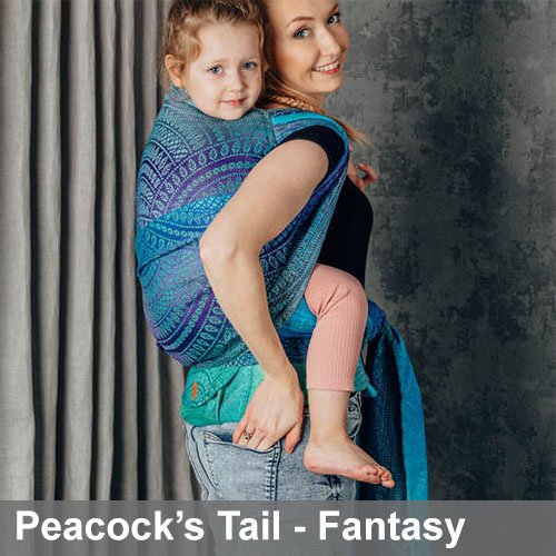 Woman carries toddler on her back in Lenny Lamb LennyHybrid Preschool toddler carrier in Peacock's Tail Fantasy, side view