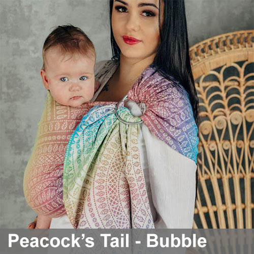 Woman carries baby on her front in Lenny Lamb Ring Sling in Peacock's Tail Bubble fabric