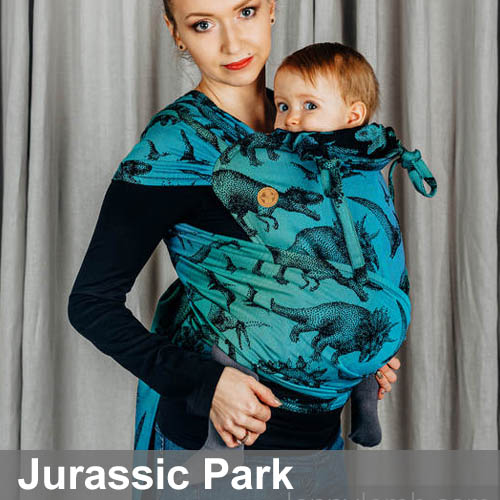 Woman carrying baby in Lenny Lamb Wrap Tai baby carrier in Jurassic Park dinosaur fabric