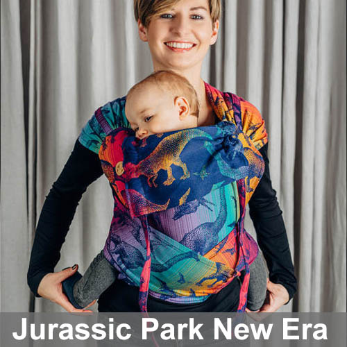 Woman carrying baby in Lenny Lamb Wrap Tai baby carrier in Jurassic Park New Era dinosaur fabric