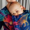 Close up of woman carrying baby in Lenny Lamb Wrap Tai baby carrier in colourful dinosaur print Jurassic Park New Era fabric