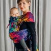 Side view of woman carrying baby in Lenny Lamb Wrap Tai baby carrier in colourful dinosaur print Jurassic Park New Era fabric