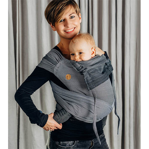 Woman carrying baby in Lenny Lamb Wrap Tai baby carrier in Little Herringbone Ombre Grey fabric