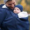 Woman carries baby on her front while wearing the Mamalila Cosy Allrounder babywearing coat in Navy