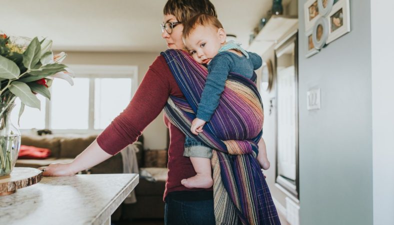 Picture of a woman with a baby on her back in a woven wrap